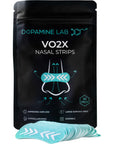 A black stand-up pouch labeled 'Dopamine Lab VO2X Nasal Strips' with a stack of light blue nasal strips placed in front on a white background.